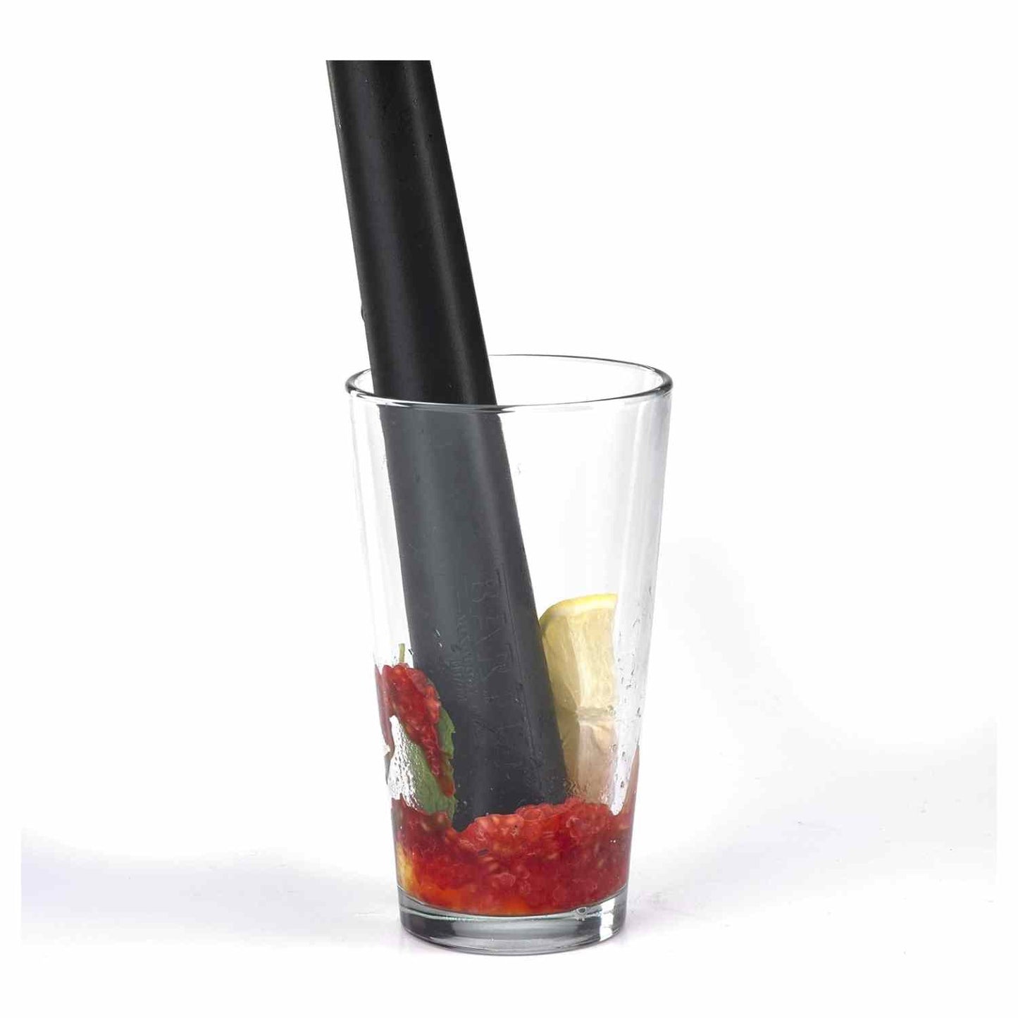 A 12-inch long, black composite bar muddler by Barfly, with a rounded base and a smooth handle crushing strawberries, raspberries, and mint in a tall, straight-sided clear glass.