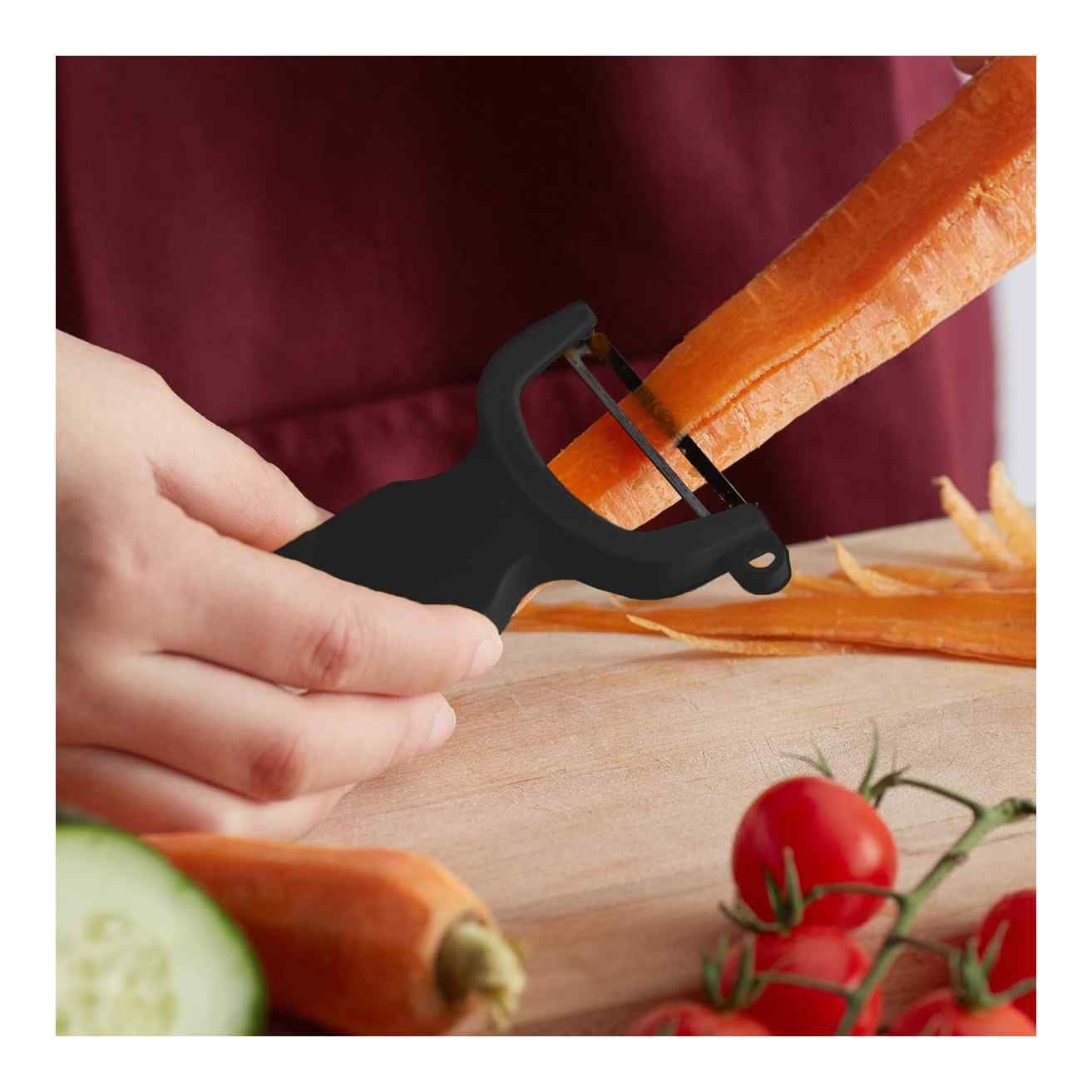 Person peeling a carrot with a Black Mercer Culinary Y Swiss Peeler on a wooden surface